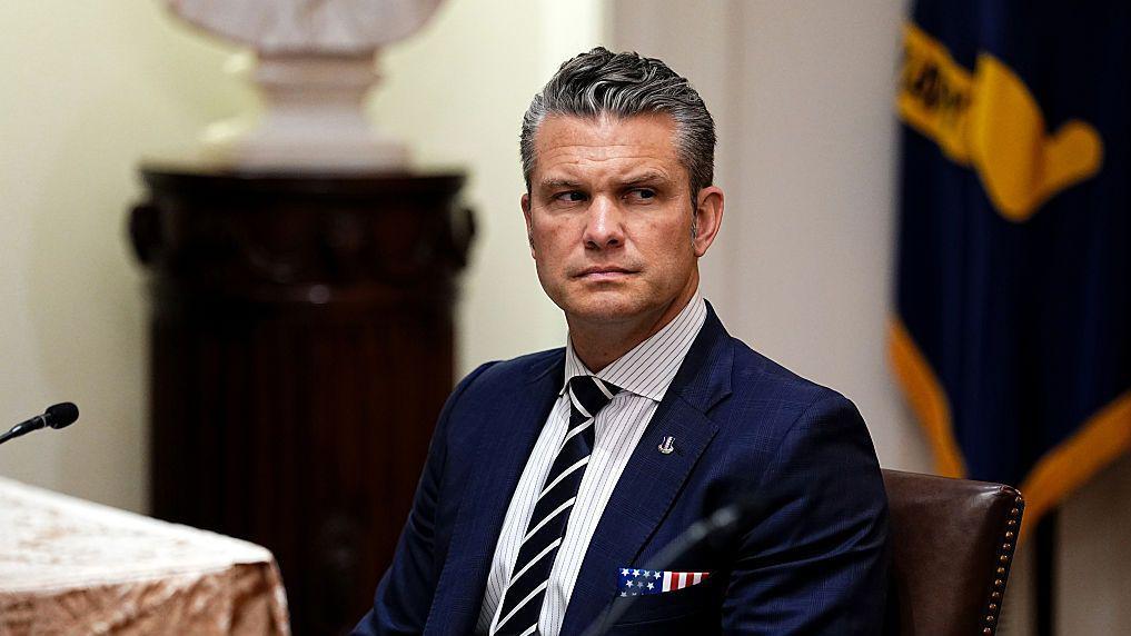 El secretario de Defensa, Pete Hegseth, sentado con una traje de corbata azul oscuro. El pañuelo en el bolsillo de su chaqueta tiene las barras y las estrellas de la bandera estadounidense. 