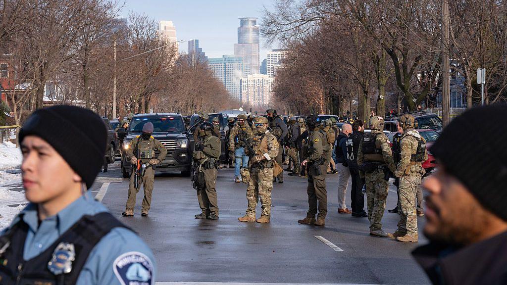 Agentes federales, incluidos de ICE y la Patrulla Fronteriza de EE. UU., y oficiales de la Policía de Mineápolis se mantienen armados a lo largo de Portland Ave. cerca del lugar donde una murió a tiros a manos de un agente Mineápolis, Minesota, el miércoles 7 de enero de 2026. (Foto de Alex Kormann/The Minnesota Star Tribune vía Getty Images)