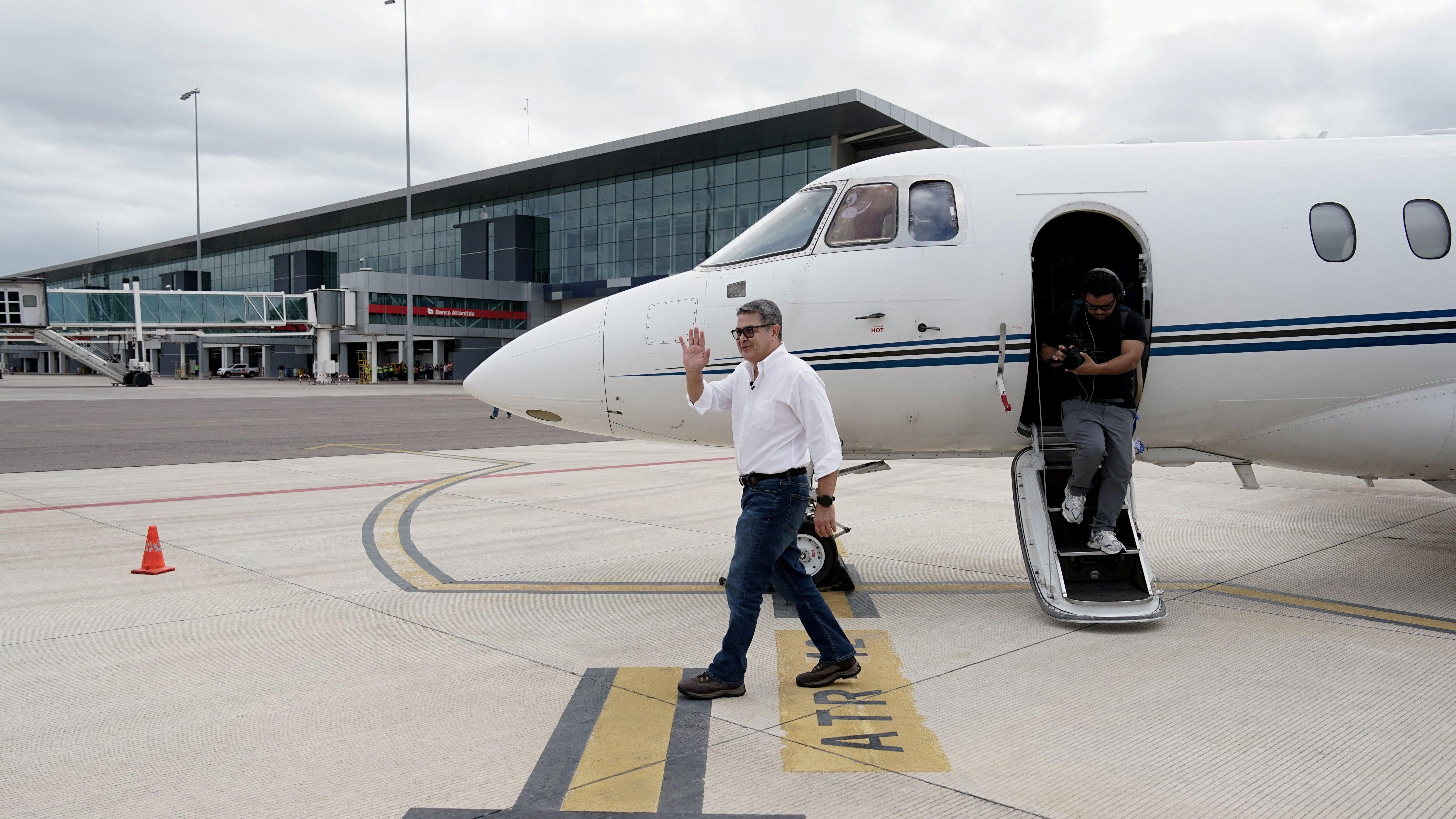 El expresidente Juan Orlando Hernández baja del vuelo privado en el que llegó a Honduras tras su indulto.