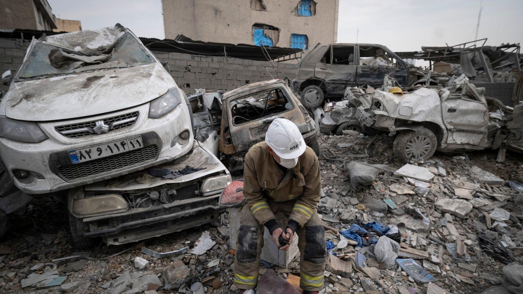 يجلس رجل إطفاء إيراني أمام مركبات مدمرة تقع على أنقاض مبنى دُمر خلال الحملة العسكرية الأمريكية الإسرائيلية التي استهدفت منطقة سكنية في 9 مارس/آذار، في طهران، إيران، في 12 مارس/آذار 2026. 