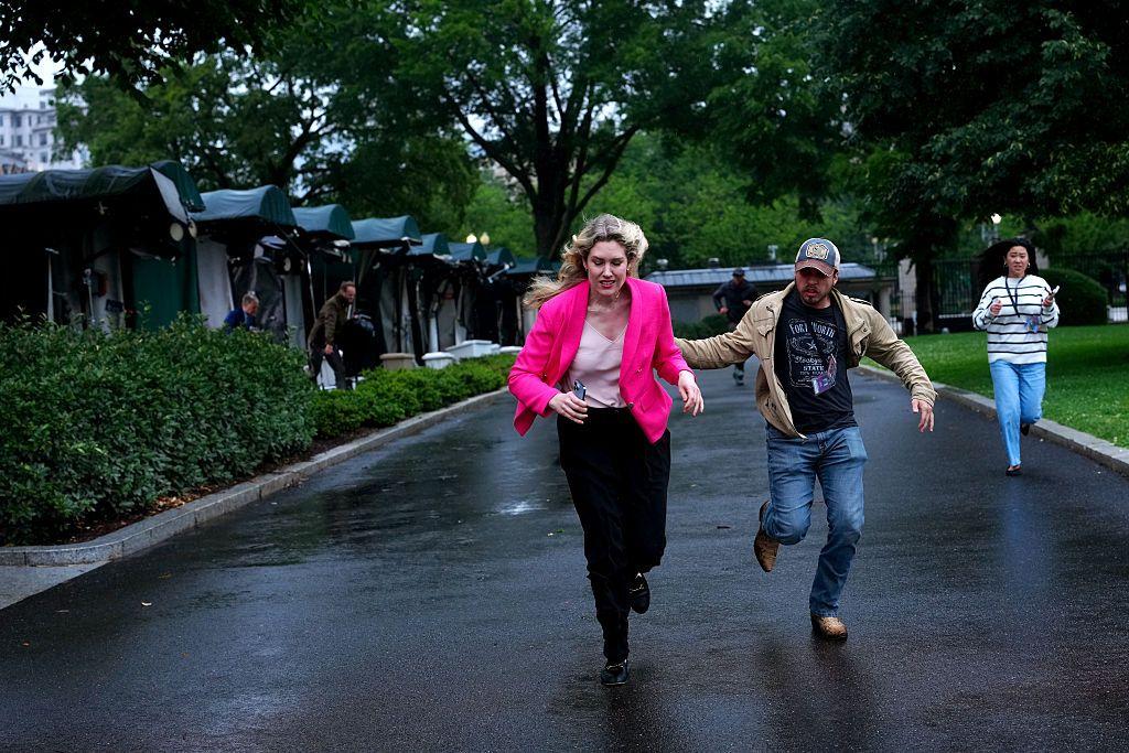 Varias personas corriendo en los jardínes de la Casa Blanca