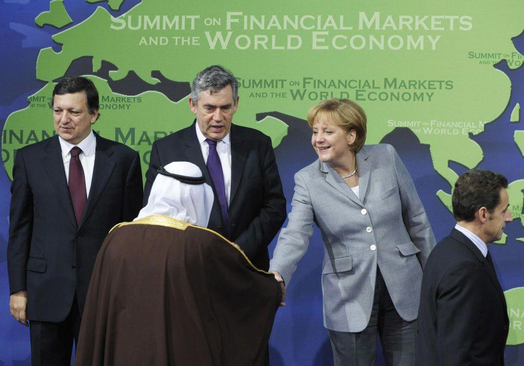 A chanceler alem&atilde; Angela Merkel (2&ordf; &agrave; direita) cumprimenta o rei saudita Abdullah Al Saud enquanto posam para a foto oficial ao lado de (da esquerda para a direita) o presidente da Comiss&atilde;o Europeia, Jos&eacute; Manuel Barroso, o primeiro-ministro brit&acirc;nico Gordon Brown e o presidente franc&ecirc;s Nicolas Sarkozy, na abertura da C&uacute;pula do G20 em 15 de novembro de 2008, em Washington.