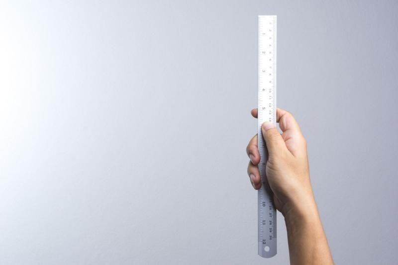 Mão segura uma régua em posição vertical