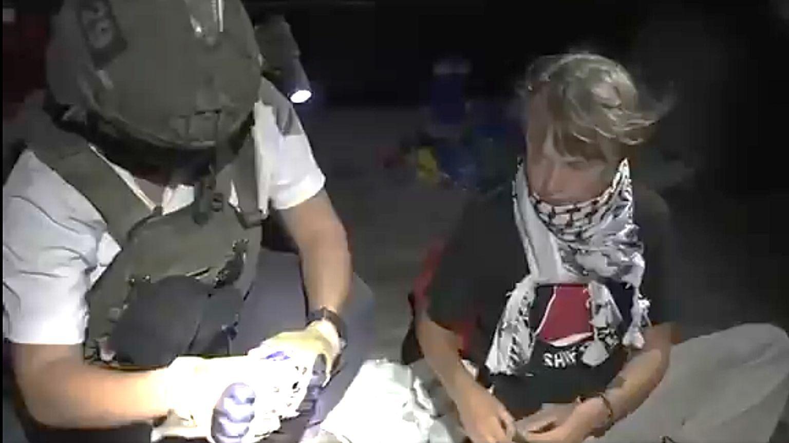 Greta Thunberg, junto a un efectivo israelí, que lleva casco y chaleco balístico. 