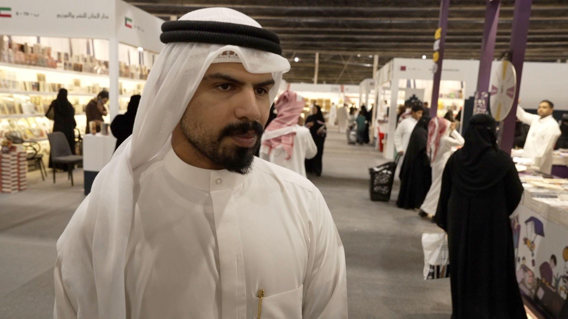 بين الانفتاح والرقابة: معرض الرياض للكتاب يكشف ملامح التحوّل الثقافي السعودي 4 الكاتب الكويتي عبد الله العنزي يرتدي جلباباً أبيض وعقالاً أبيض ويعلو وجهه شارب.