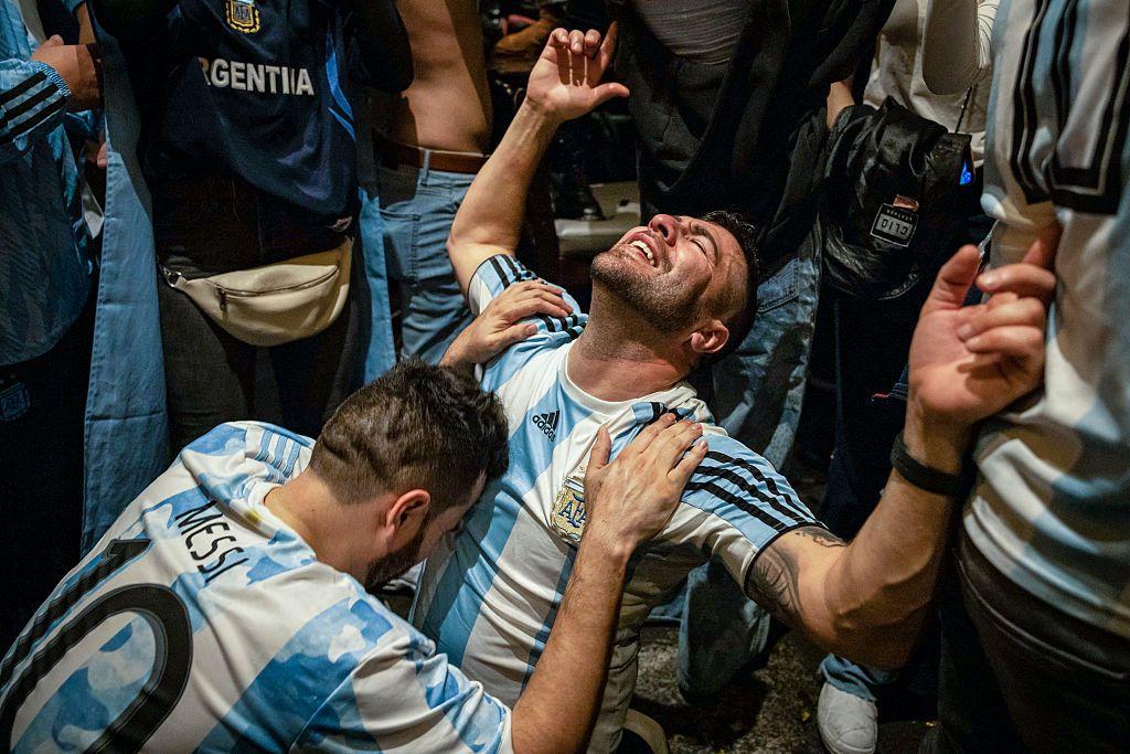 Hombre se abraza a otro durante la celebración por el triunfo de Argentina en el Mundial de 2022
