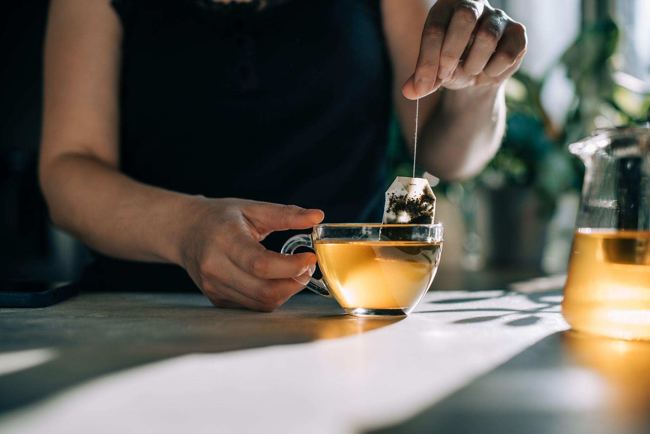 Una persona se hace un té en una taza transparente.
