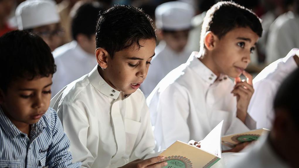 أطفال مسلمون يقرؤون القرآن الكريم أثناء إحياء ليلة القدر في رمضان، في المنامة- البحرين، في 28 يونيو/ حزيران 2016.