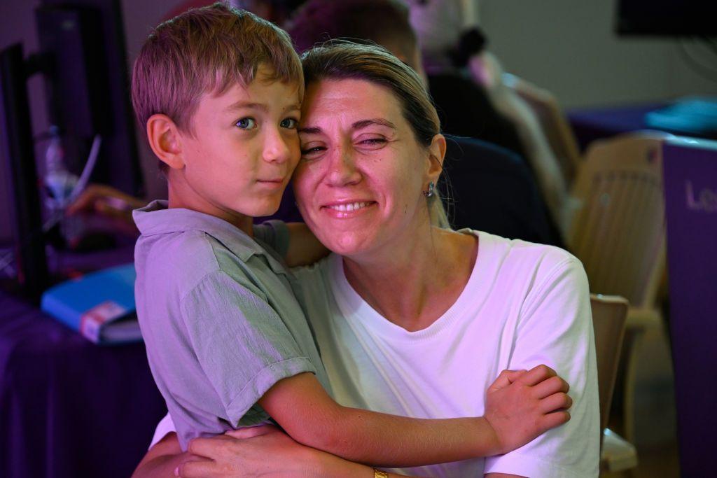 Mãe abraçada com um filho na agência de imigração de Portugal