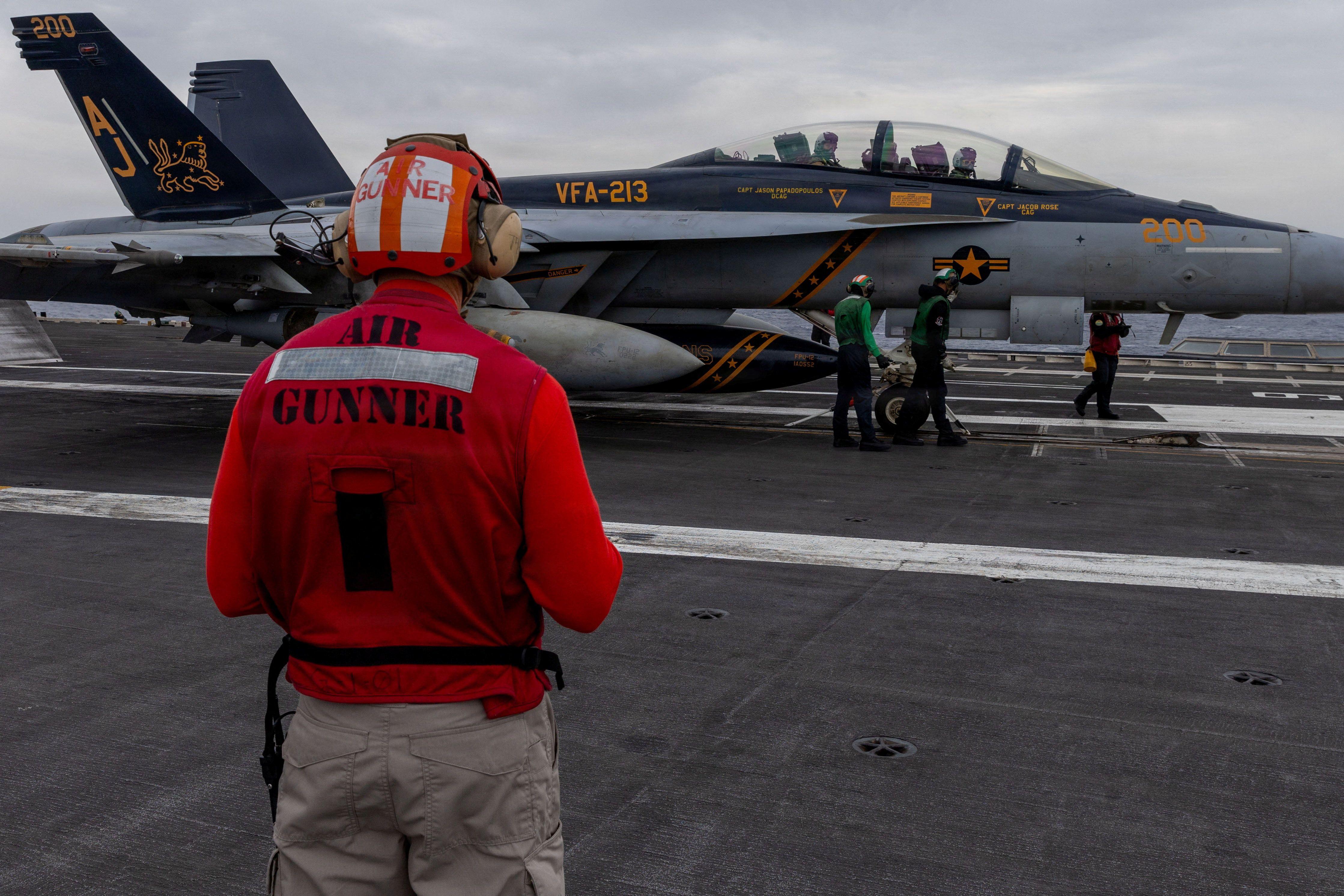 Un marinero estadounidense observa la inspección previa al despegue de un avión F/A-18F Super Hornet en la cubierta de vuelo del portaaviones USS Gerald R. Ford durante la operación "Furia épica", un ataque contra Irán lanzado desde una ubicación no revelada el 15 de marzo de 2026.