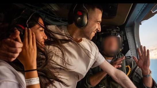 Casal dentro de helicóptero no ar sorrindo