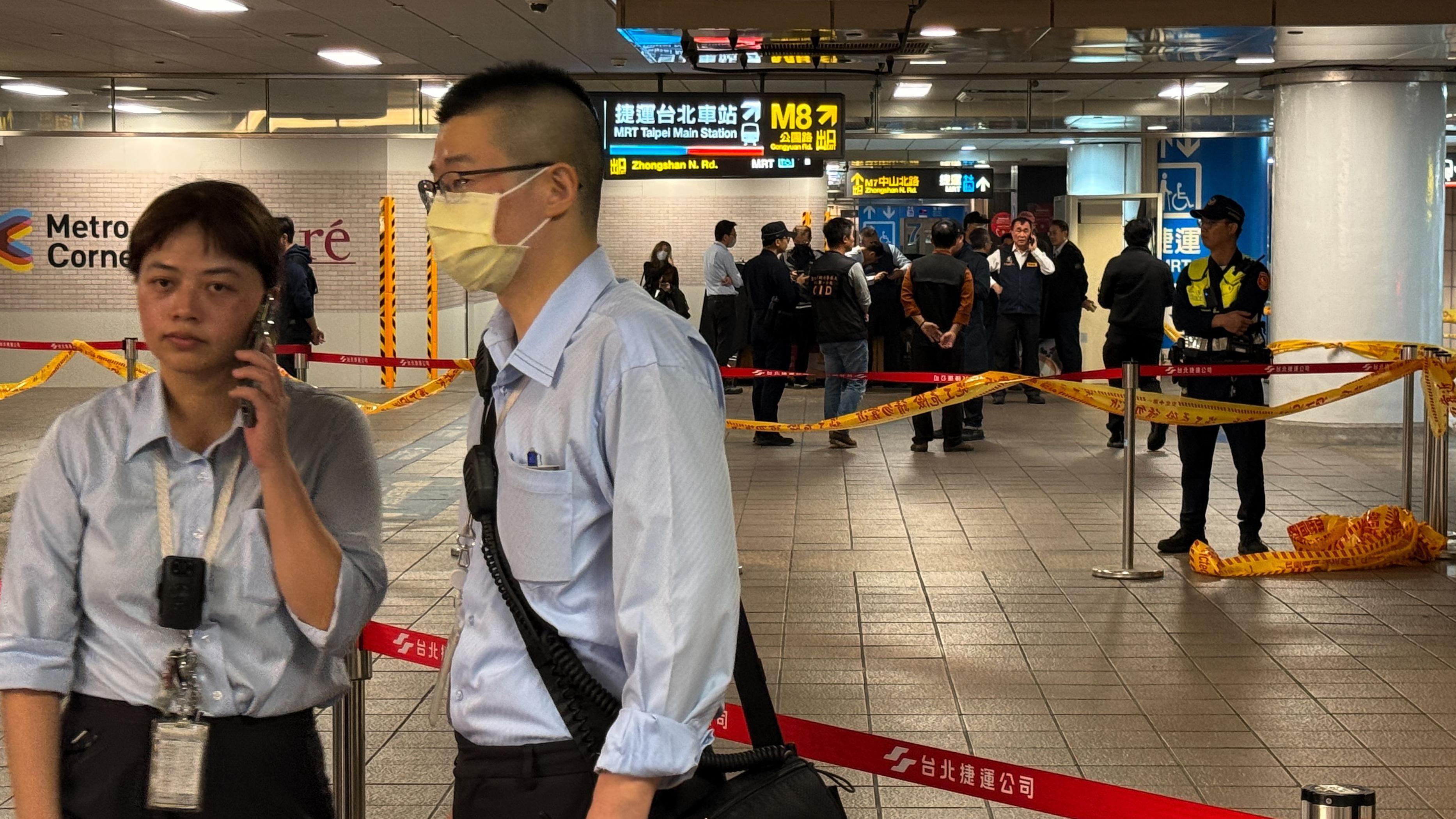 兩名台北捷運職員站在警察封鎖線外通訊（19/12/2025）
