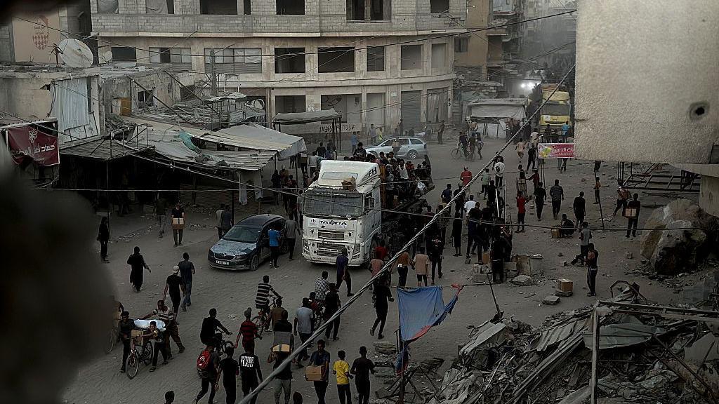 Una vista de palestinos desplazados viajando por una ruta conocida como el "camino de la muerte" para recibir paquetes de alimentos de los puntos de ayuda a pesar del intenso bombardeo israelí y la amenaza de francotiradores en Jan Yunis, Gaza.