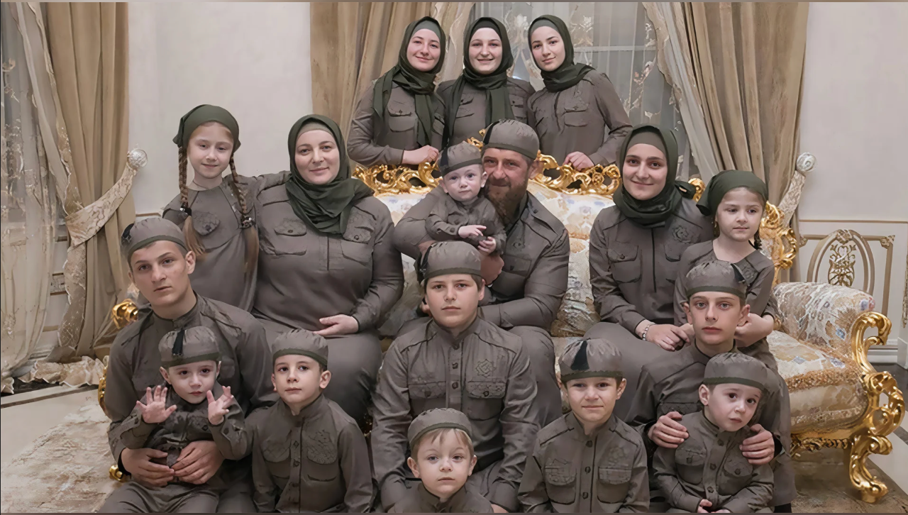 Рамзан Кадиров у колі сім'ї - всі одягнені в однакову уніформу брудно-коричневого кольору. У чоловіків на головах шапочки, у жінок - хустки того ж кольору.