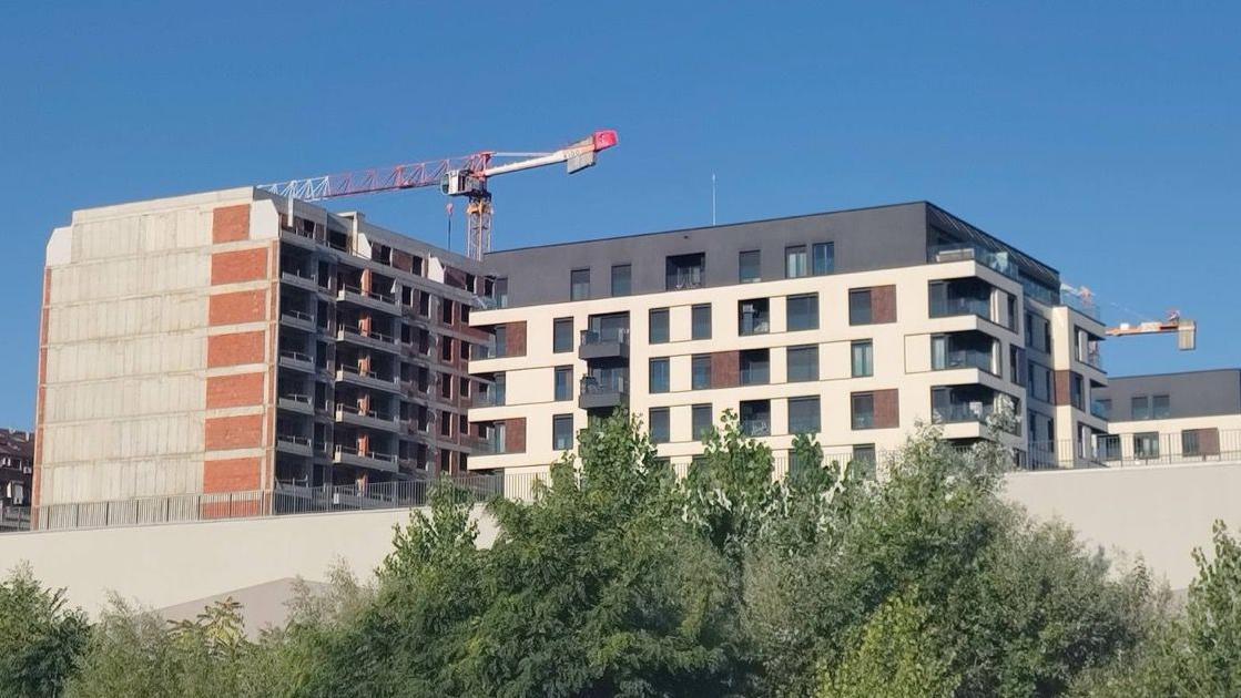 Zgrada u izgradnji iznad koje je građevinski kran, desno od nje je završen stambeni objekat
