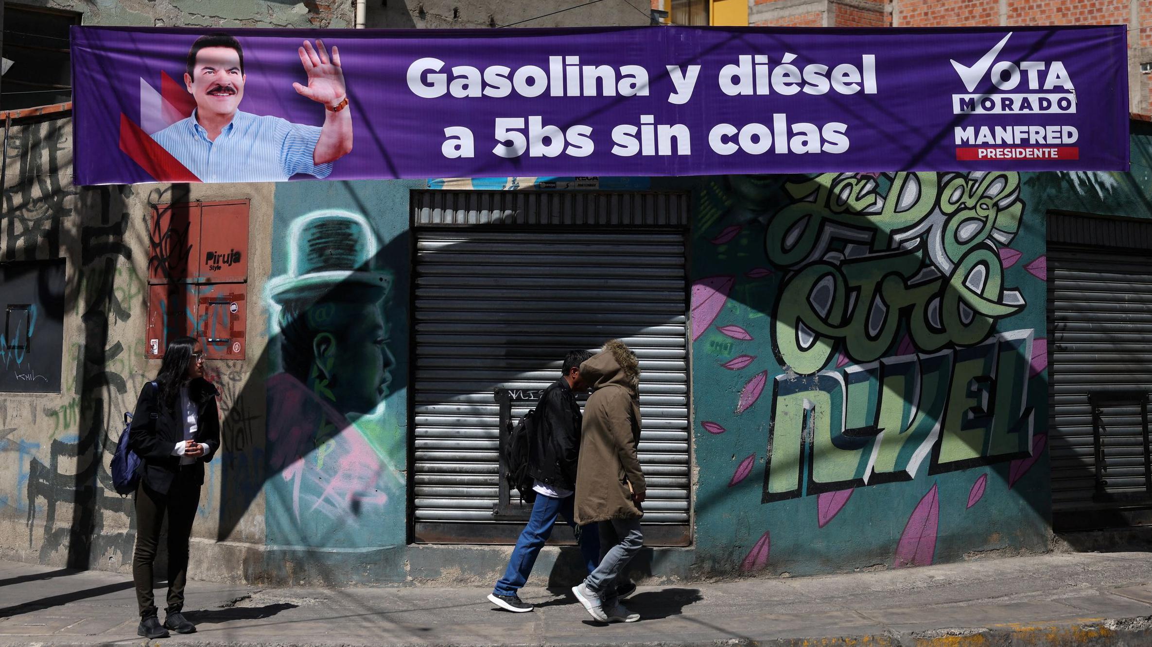 La gente pasa junto a una pancarta del candidato presidencial boliviano Manfred Reyes Villa, del partido "Súmate", en La Paz.