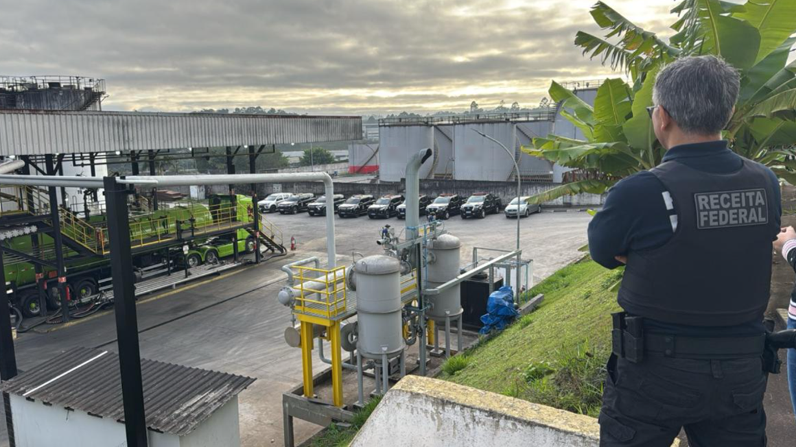 Agente da pol&iacute;cia federal observa do alto de um barraco refinaria de combust&iacute;vel