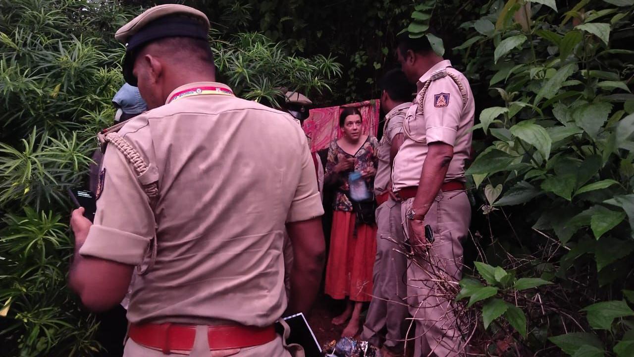 Policías hablando con una mujer rusa que se encuentra fuera de una cueva.