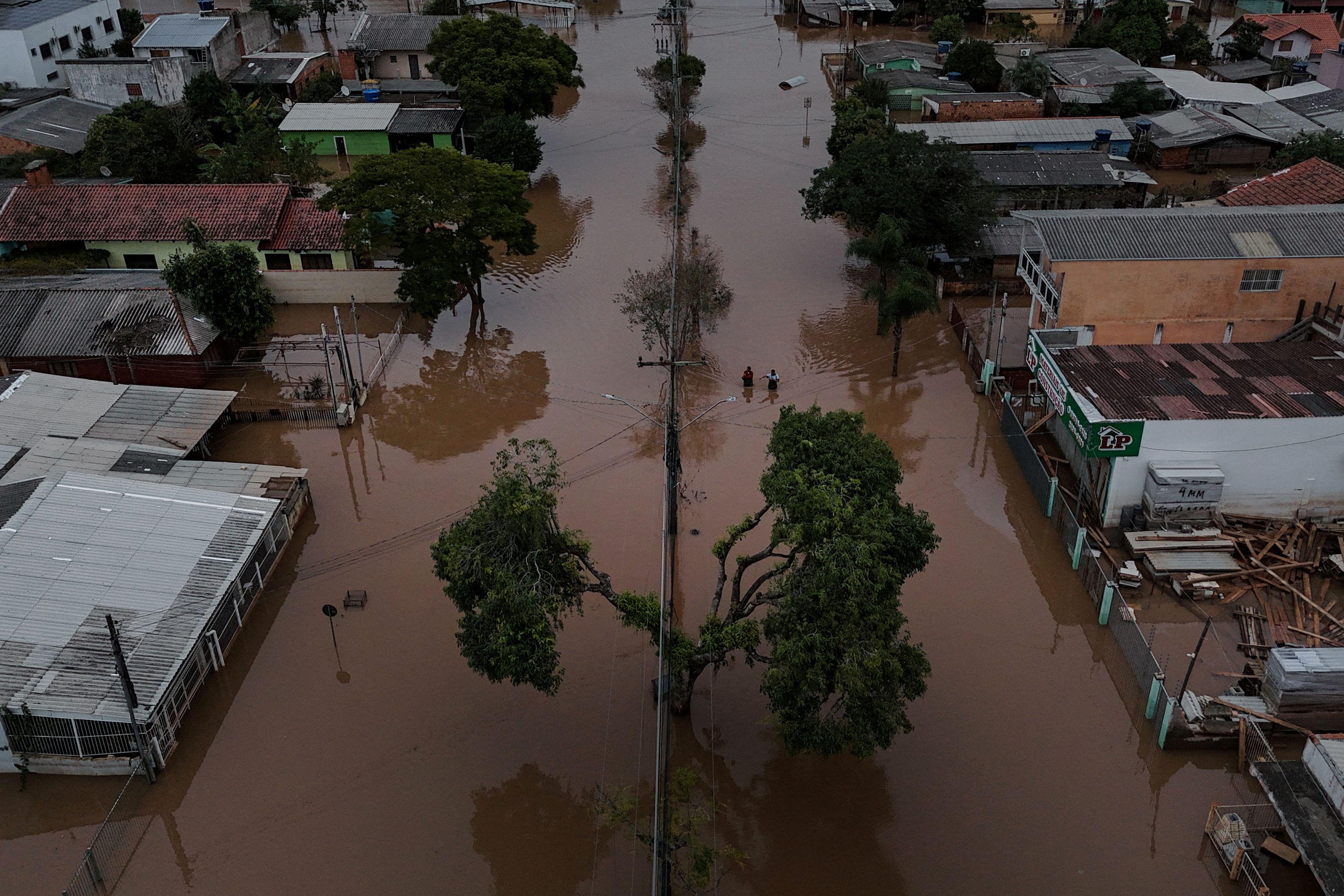 Imagem de drone mostra pessoas caminhando em uma rua inundada em Eldorado do Sul, no Rio Grande do Sul, em 10 de maio de 2024. 