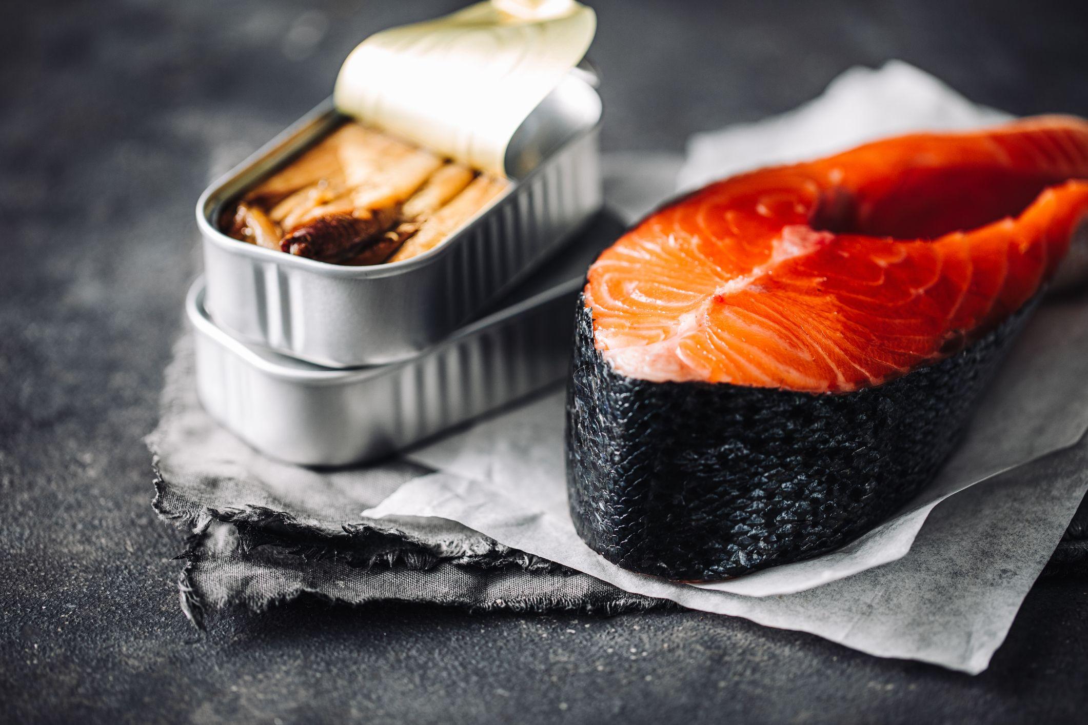 Una lata de sardinas frente un filete de salmón