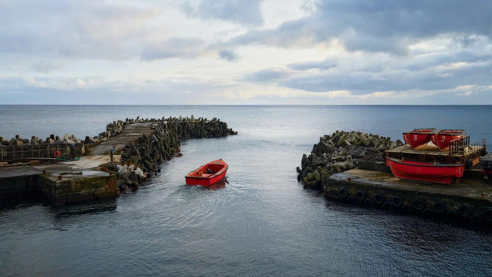 Barca vacía, puerto, mar y horizonte