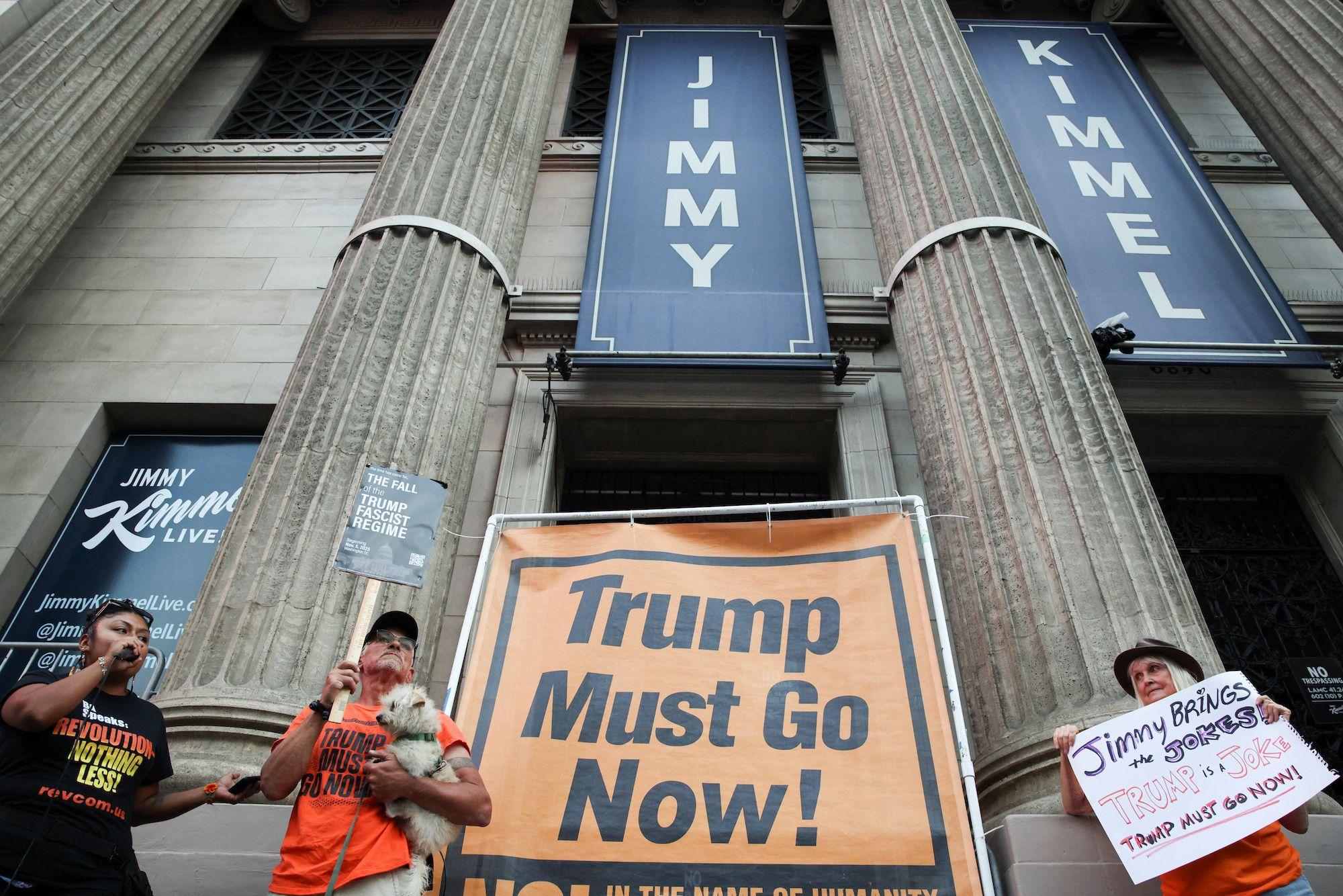 Manifestantes em frente a local com cartaz de Jimmy Kimmel