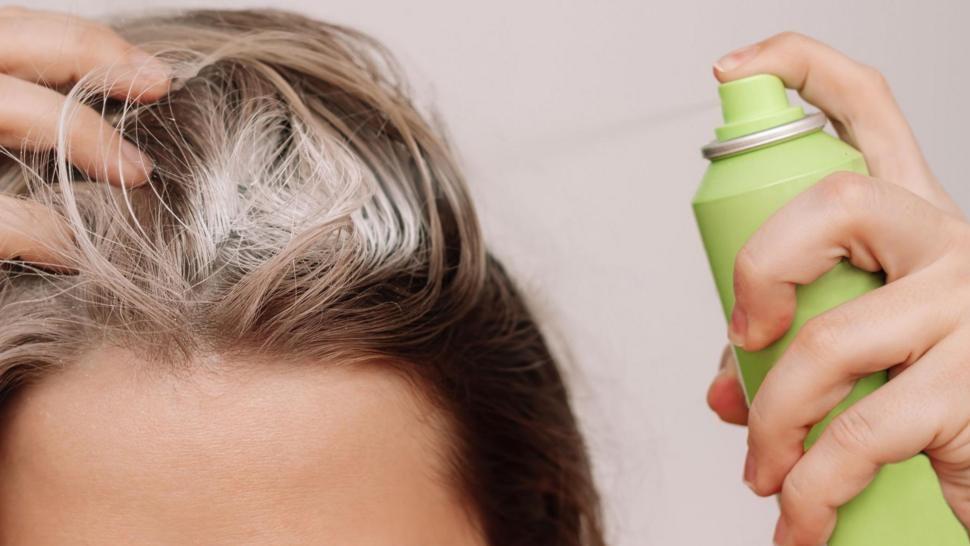 Mujer utilizando champú seco