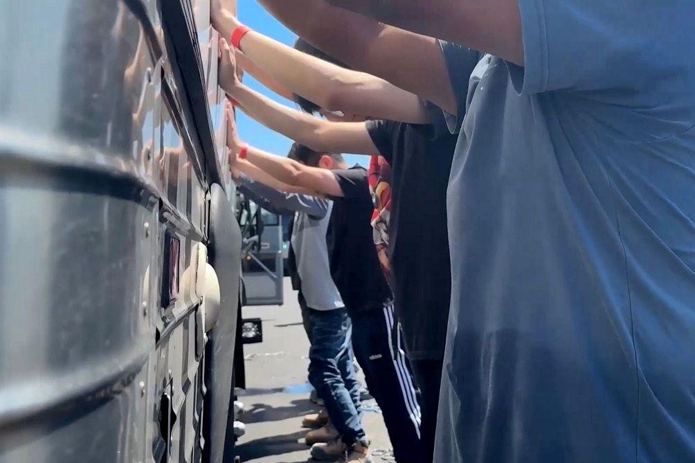 Para pekerja di pabrik Hyundai dibariskan dan digeledah oleh aparat imigrasi AS. 