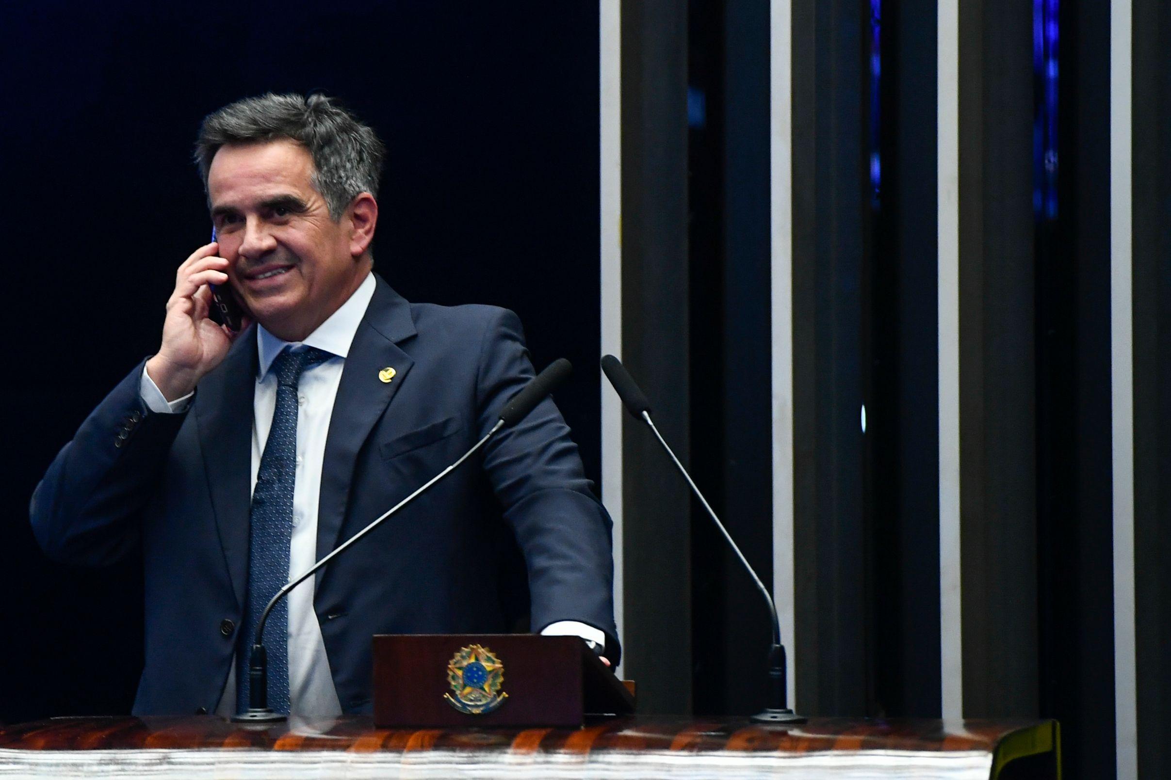 Ciro, de terno, fala ao celular e sorri, da tribuna do Senado Federal