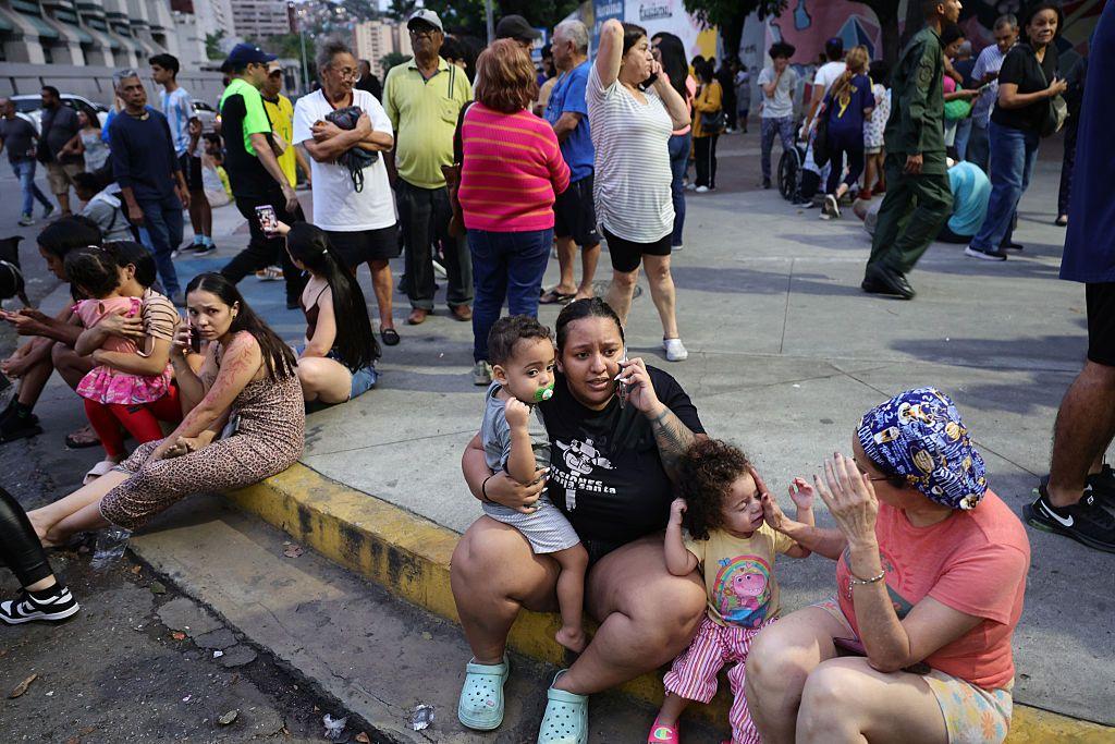 Personas evacuadas hablan por teléfono mientras aguardan en el complejo urbanístico Parque Central, en Caracas, tras el terremoto de magnitud 7,2 que sacudió Venezuela
