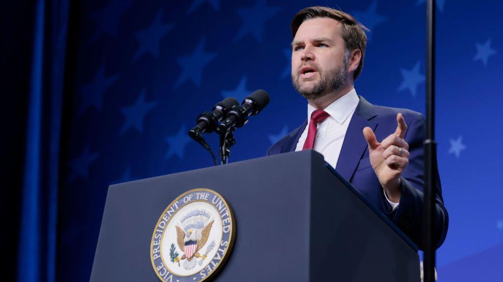 نائب الرئيس الأمريكي جيه دي فانس يقف في إحدى المؤتمرات يلقي خطابا 