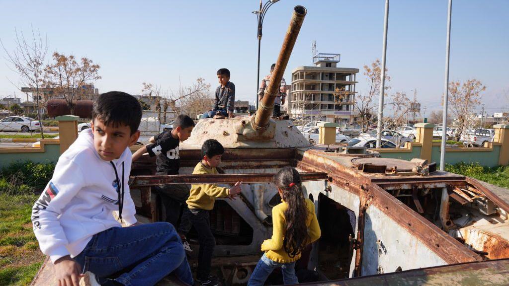 أطفال أعلى حطام دبابة