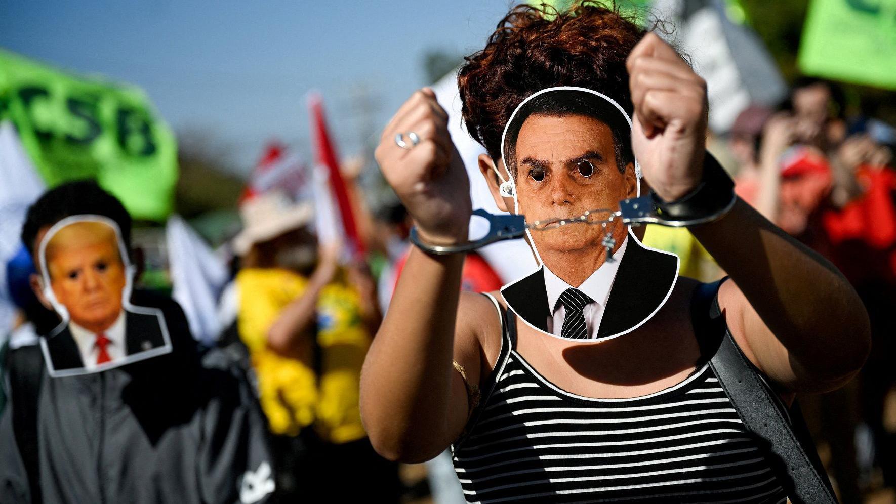 Manifestante usa máscara com rosto de Bolsonaro e algemas nas mãos