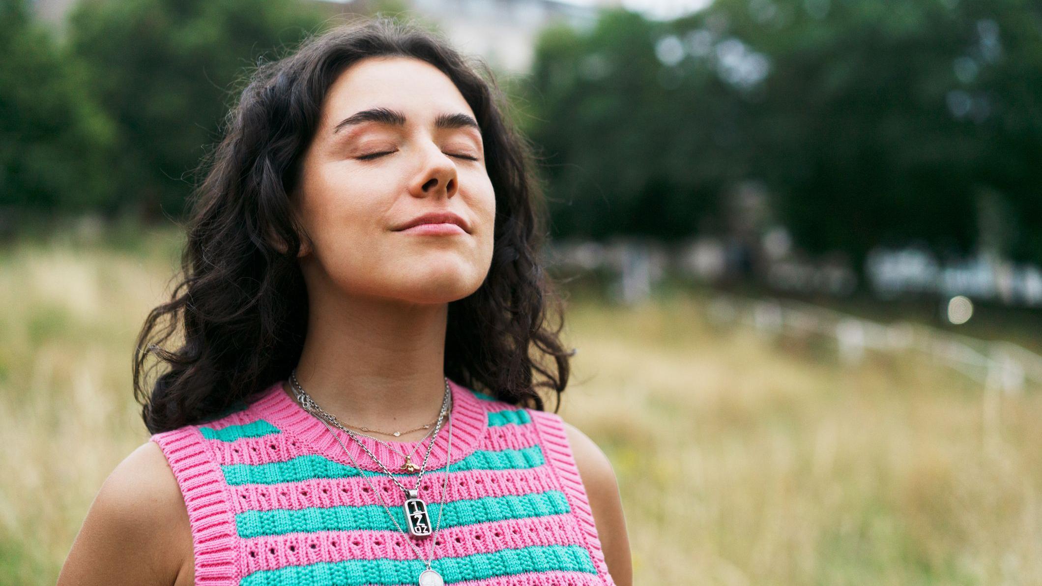 Mujer con los ojos cerrados, relajada, en estado de plena consciencia