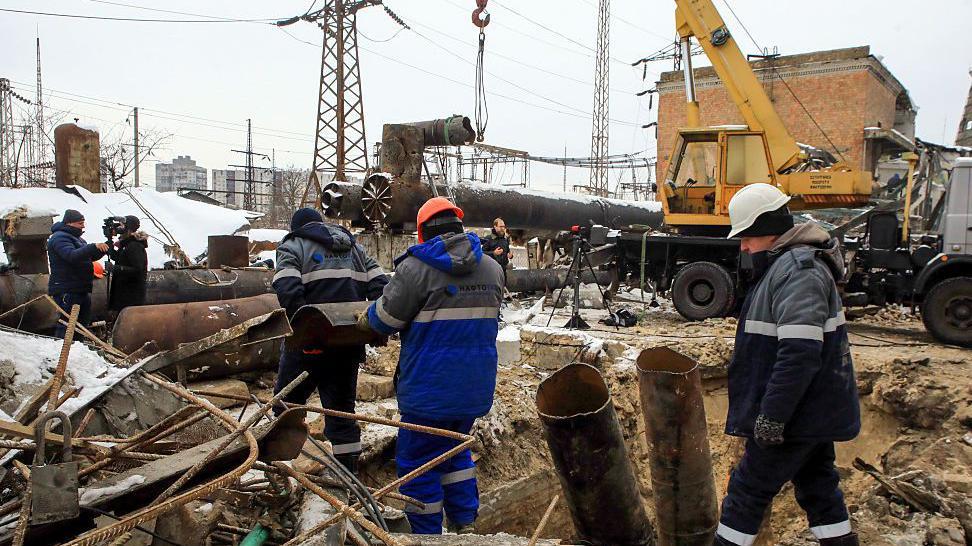 Trabajadores de la empresa eléctrica ucraniana inspeccionan los daños a una planta cerca de Kyiv.