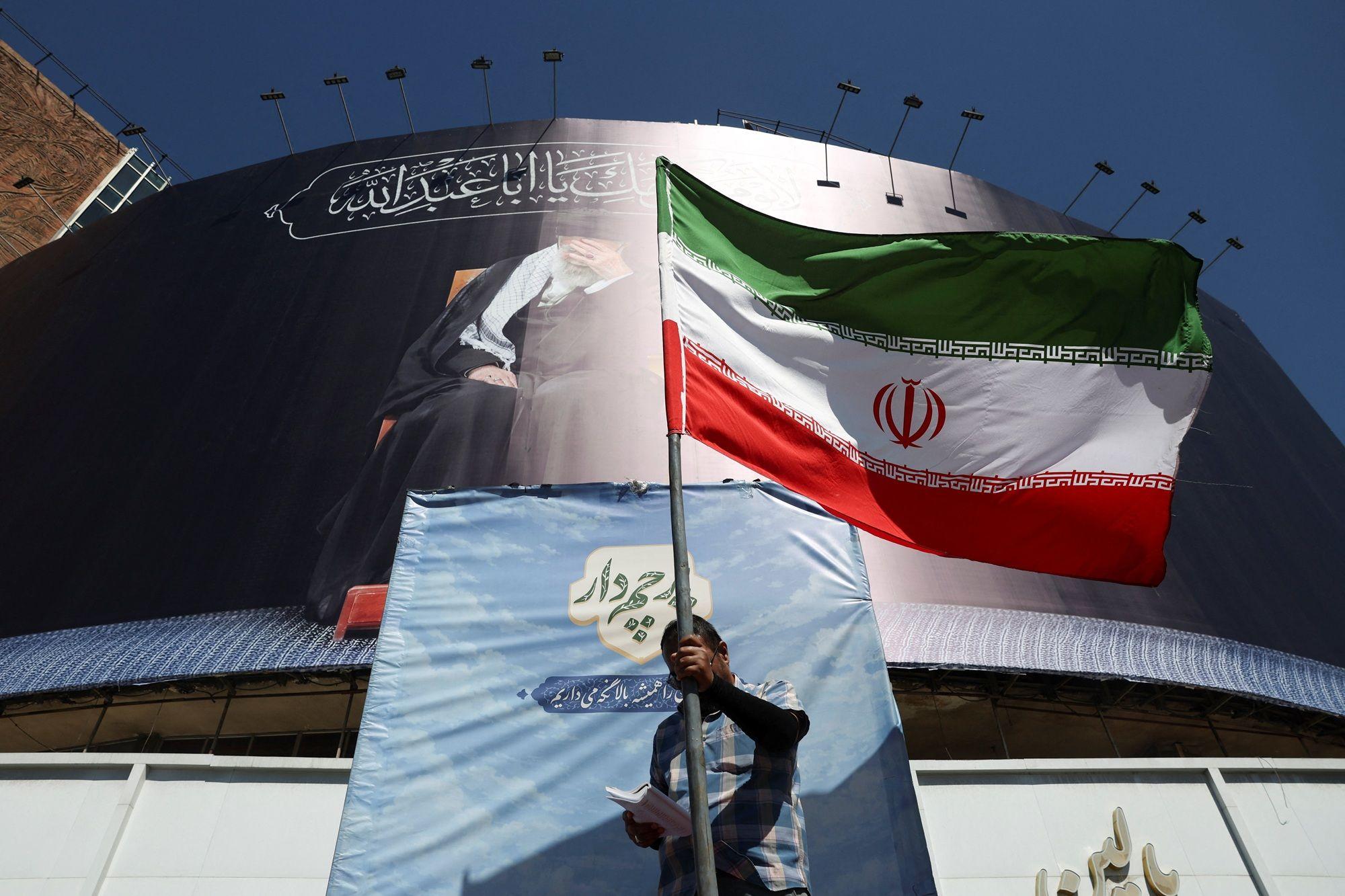 رجل يحمل العلم الإيراني في أحد شوارع طهران، إيران، في 15 يونيو/حزيران 2026، بعد أن أعلن مسؤولون أمريكيون وإيرانيون عن توصلهم إلى اتفاق لإنهاء الحرب وإعادة فتح مضيق هرمز.