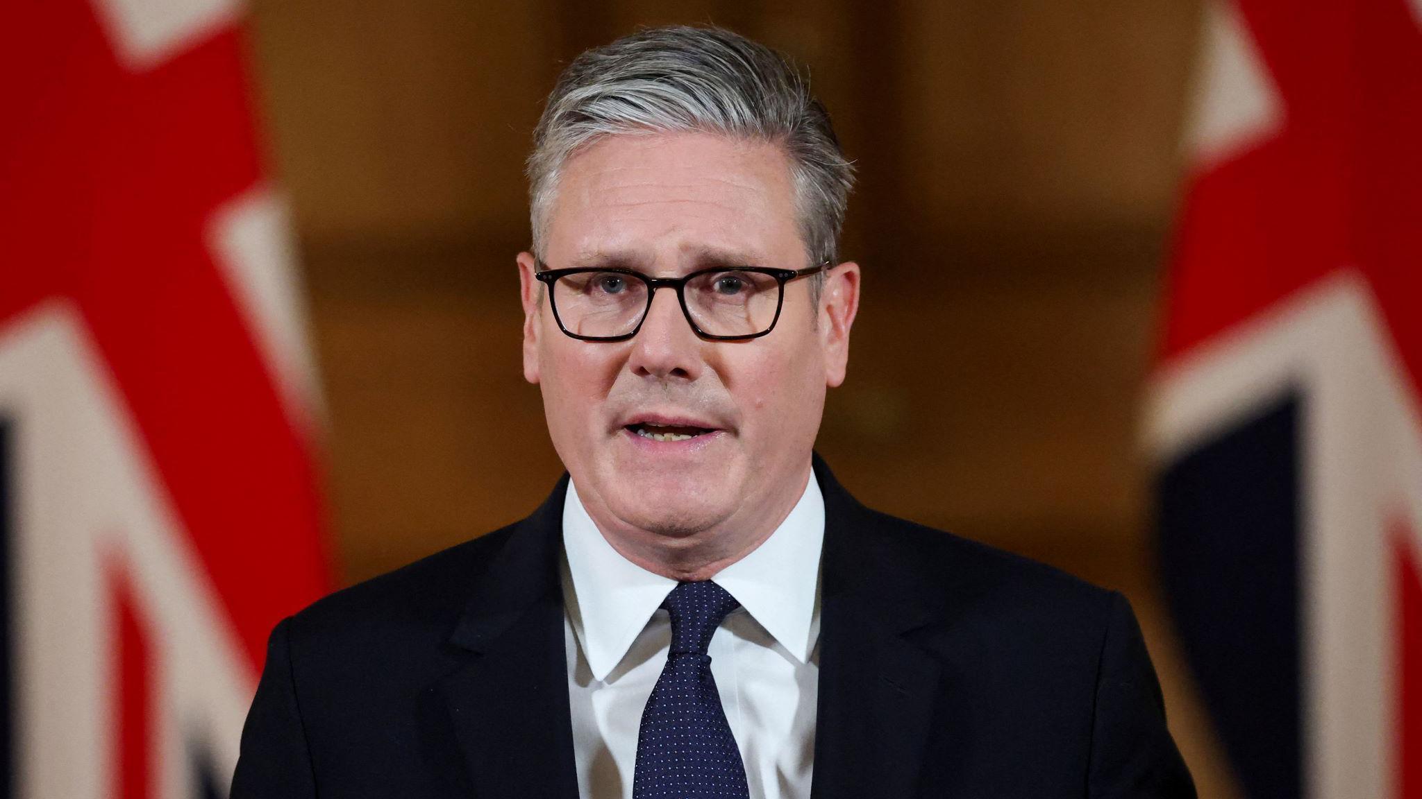 英國首相施紀賢爵士（Sir Keir Starmer，基爾·斯塔默）站在英國國旗前發表電視講話