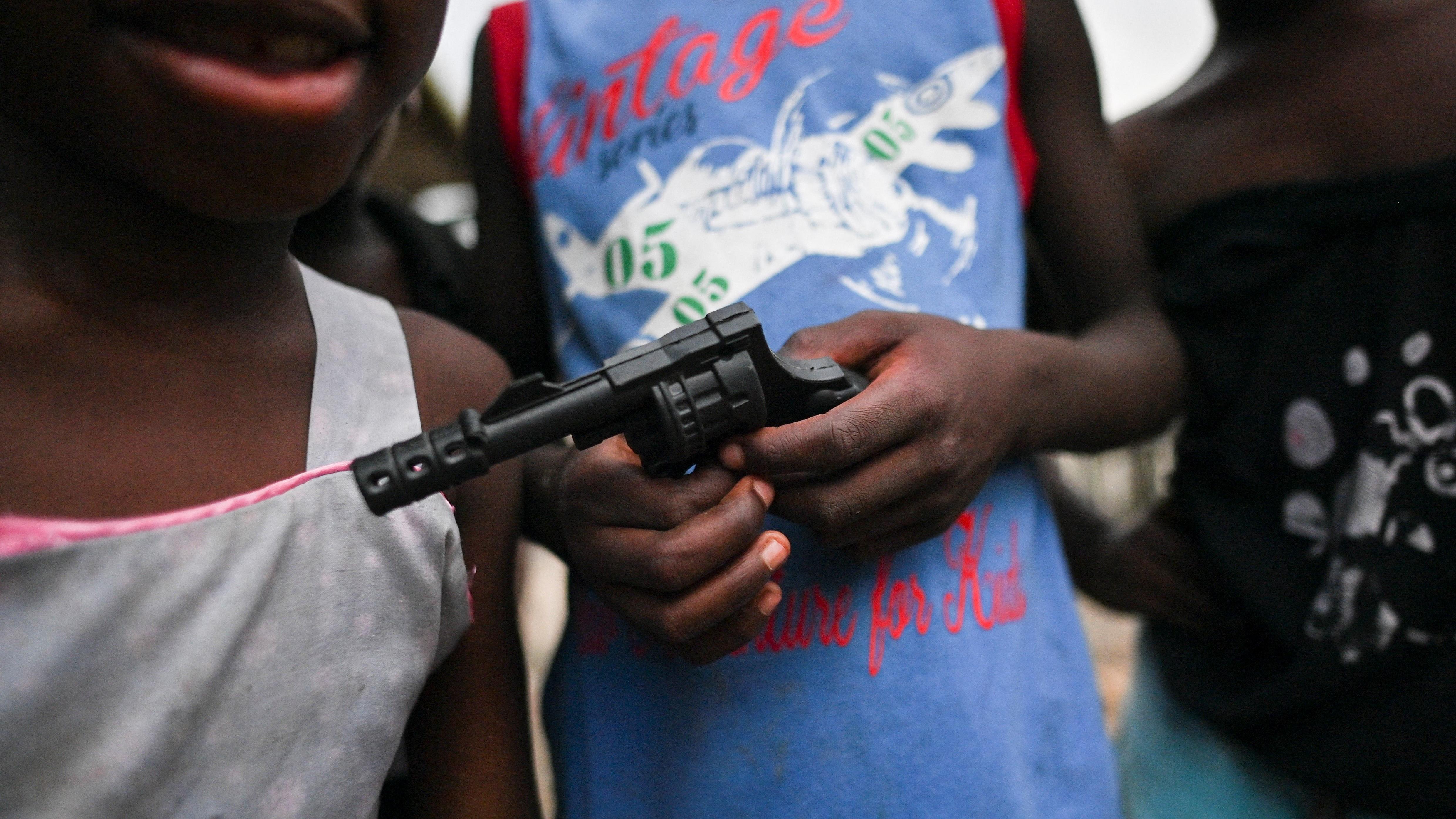Niños sostienen una pistola de juguete en Buenaventura, Colombia, en 2021.