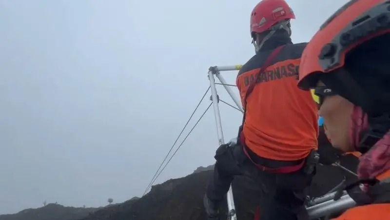 Equipe de resgate trabalhando em vulc&atilde;o, puxando cordas