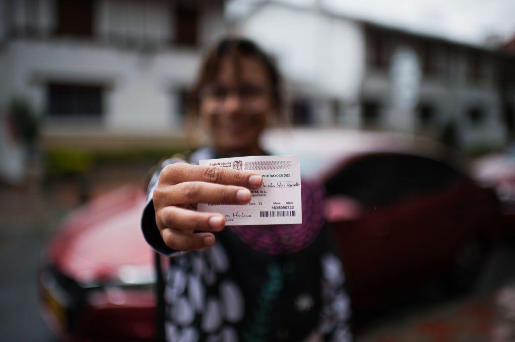 Mujer muestra su certificado electoral. 