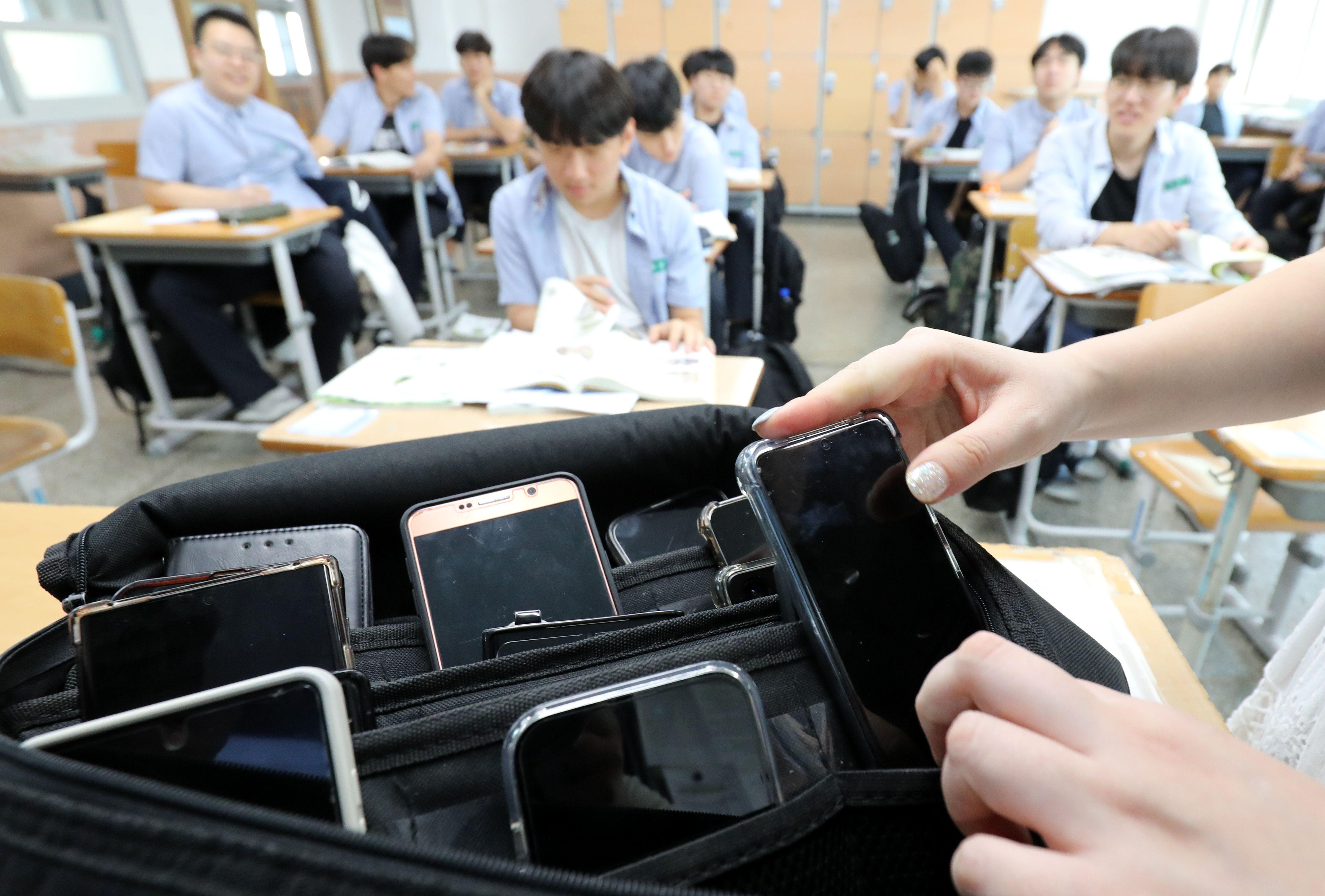 스마트폰을 수거해 보관함에 넣고 있는 대전의 한 고등학교 교실의 모습