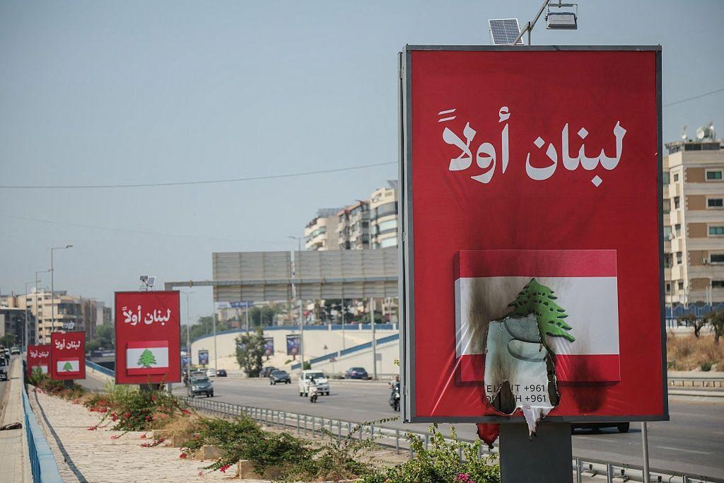 سيارات تمر قرب لافتات “لبنان أولاً” على طريق مطار بيروت، بعدما رفض حزب الله الاتفاق الإطاري بين لبنان وإسرائيل واتهم الحكومة بتقويض السيادة اللبنانية.