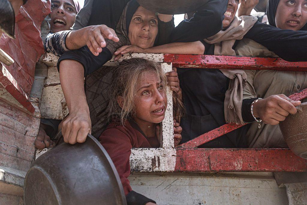 Palestinos, incluidos niños, se agolpan para recibir comida distribuida por organizaciones de ayuda en la ciudad de Gaza el 26 de julio de 2025.