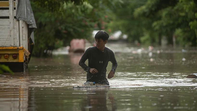 Un joven intenta avanzar con el agua casi a la altura de la cadera