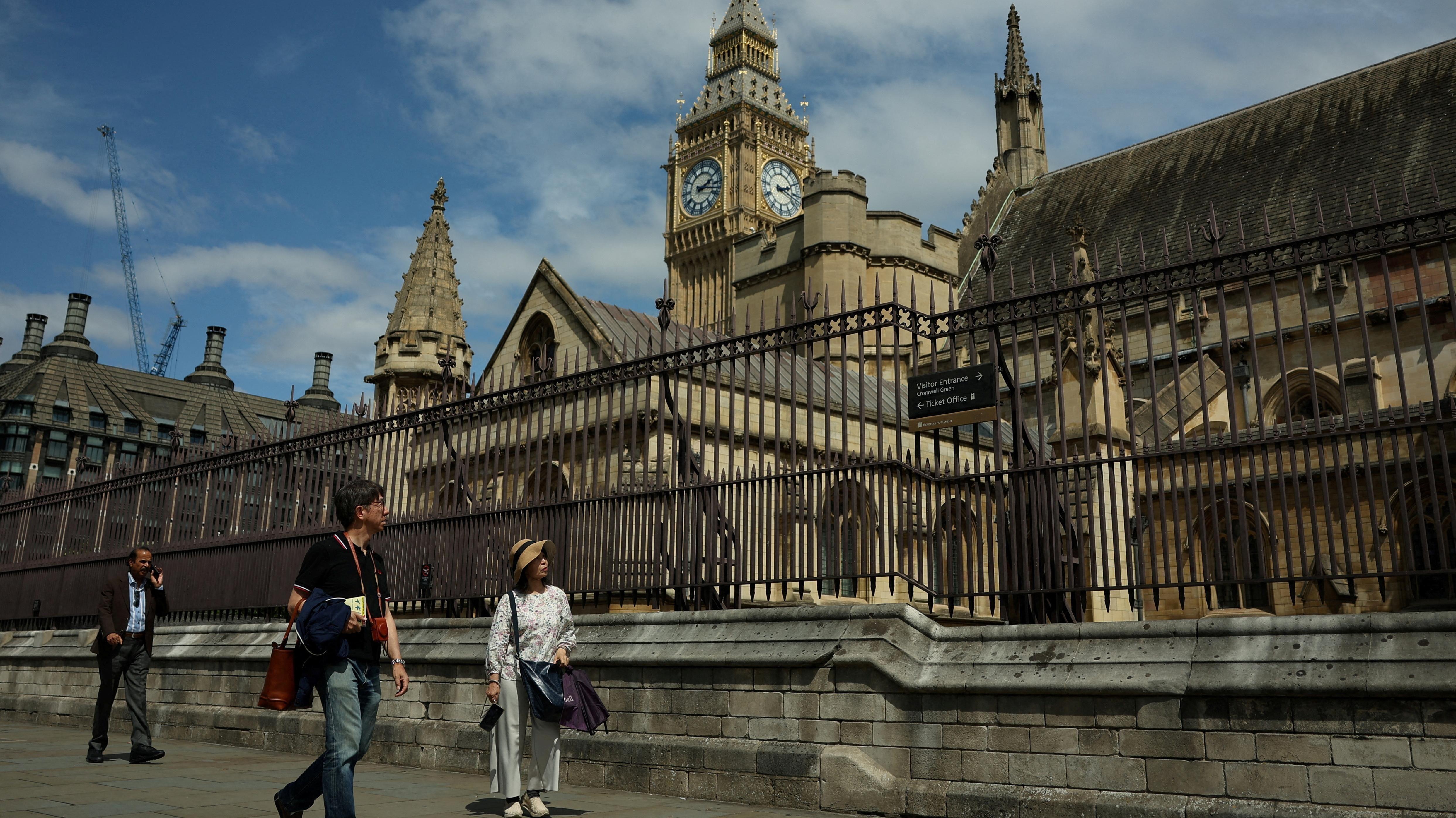 يمر السياح بجوار برج إليزابيث المعروف بساعة بيغ بن ومباني البرلمان 