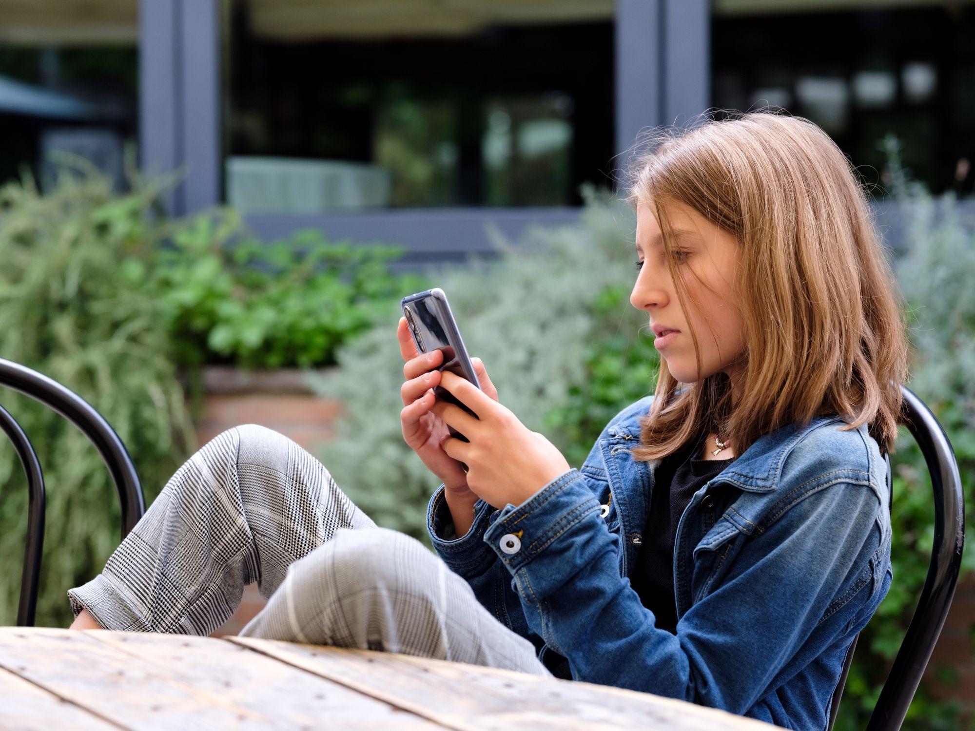 Menina olhando seu telefone celular