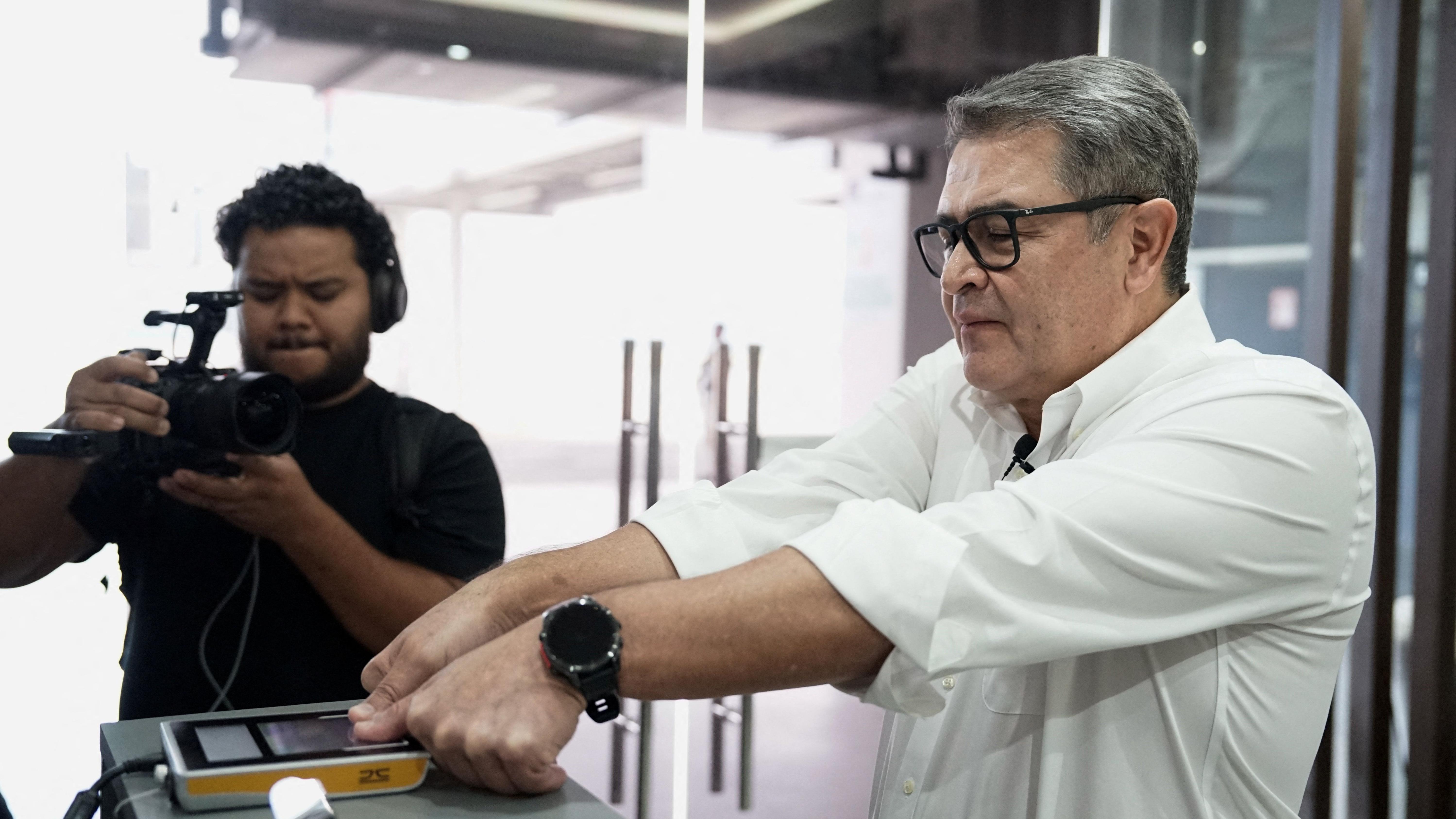 Juan Orlando Hernández pasa por control de migración en el aeropuerto.