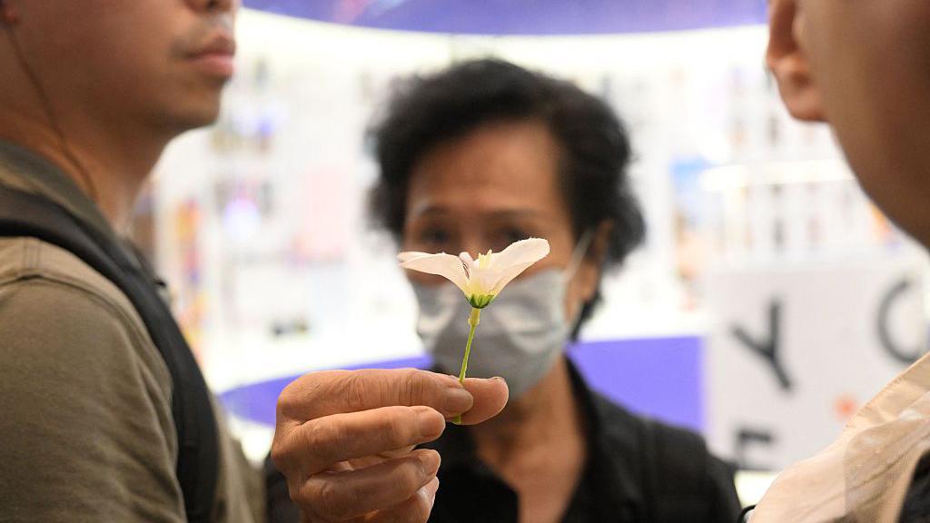 2025年6月4日，警方在香港銅鑼灣包圍一名手持小白花的女士