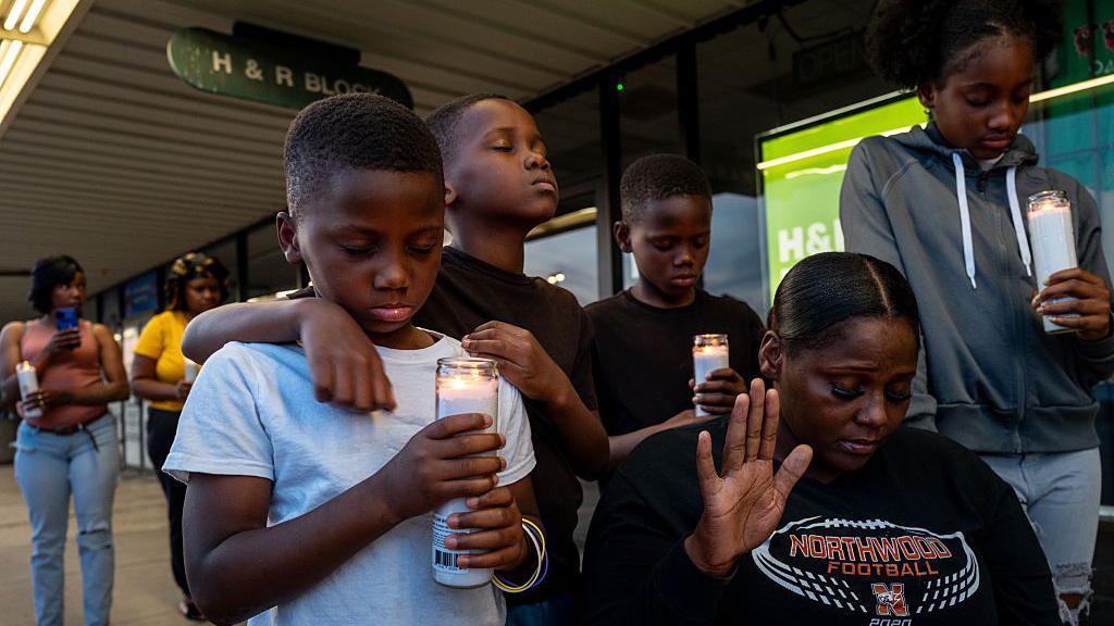 A fam&iacute;lia Johnson participa de uma vig&iacute;lia &agrave; luz de velas.