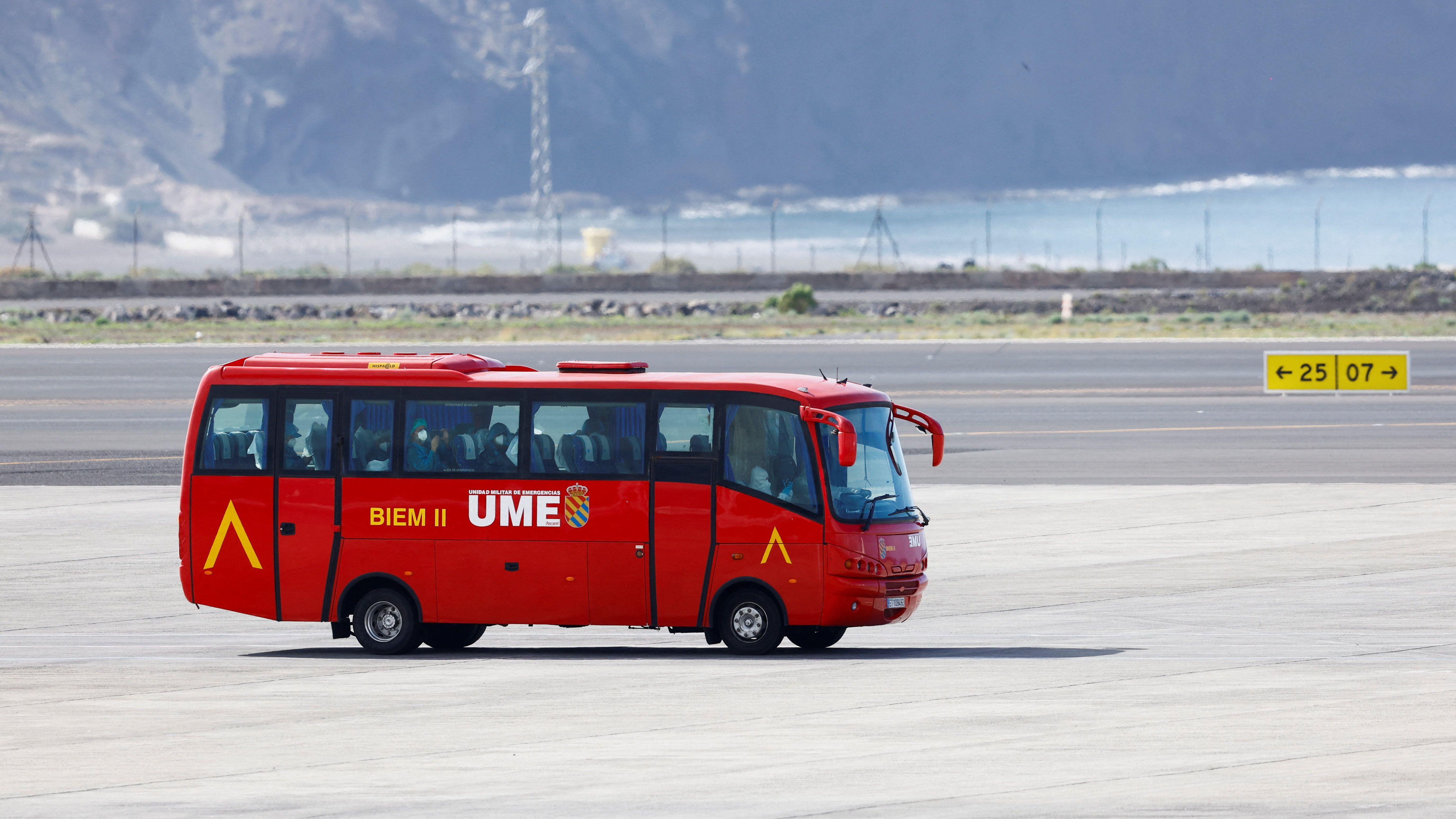 A red bus transports passengers evacuated from the cruise ship. 